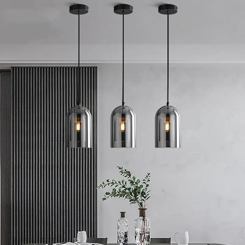 Three modern luxury amber glass wall art lights with smoked glass domes and black cords for bedroom wall art light