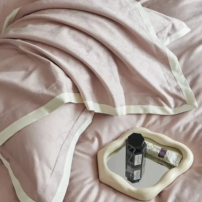 Luxury blush pink satin duvet cover set with silver floral embroidery and cream piping for elegant bedroom bedding