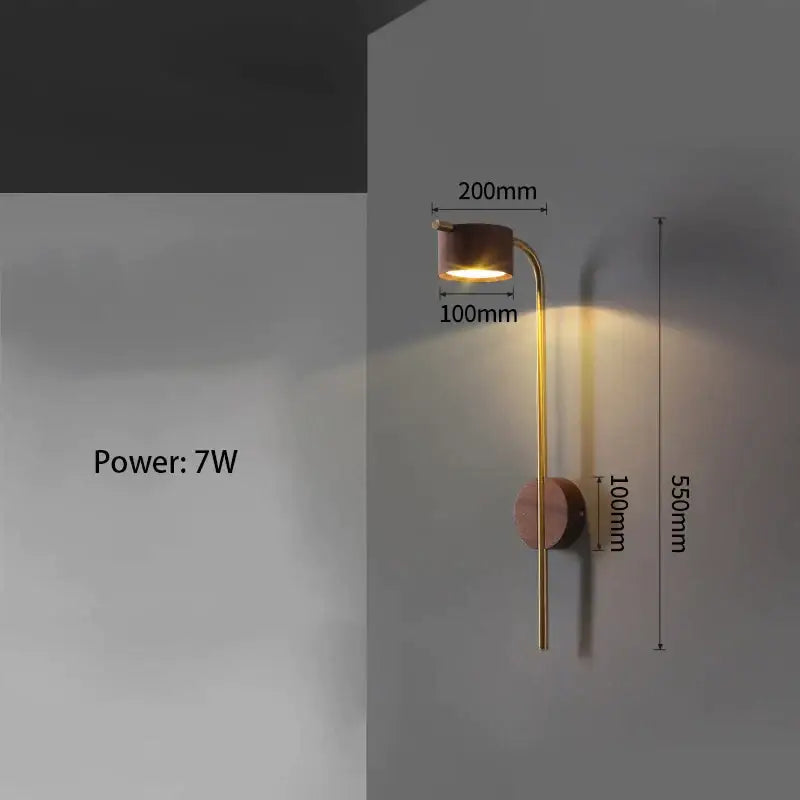 A sleek brass wall lamp with black walnut wood base and curved arm emitting warm light for bedroom reading
