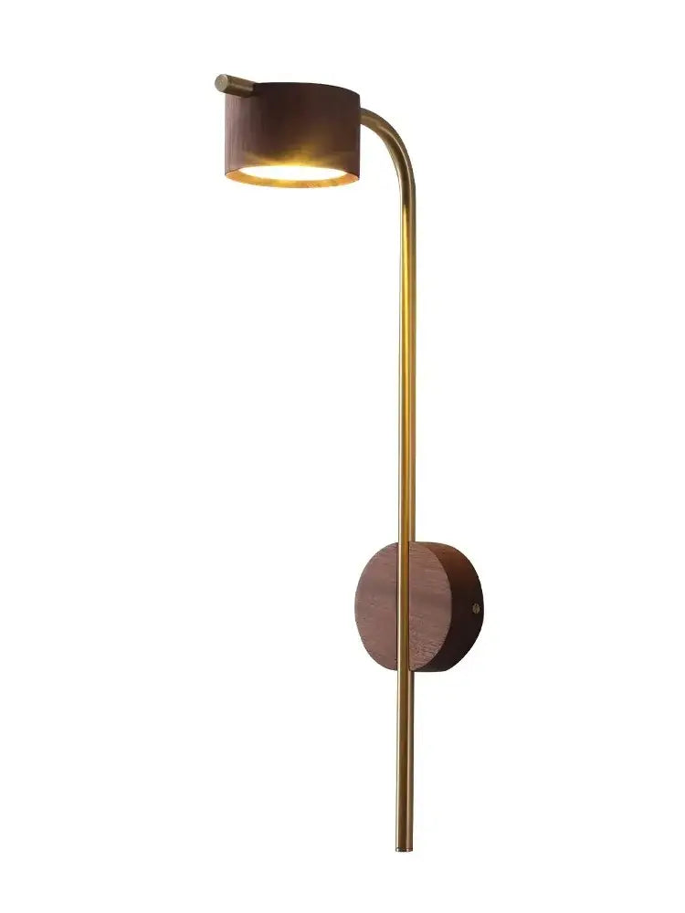 A sleek brass wall lamp with a warm cylindrical black walnut wood shade and elegant curved arm for bedroom reading