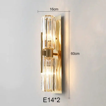Luxury brass crystal wall lamp with gold-toned metallic backplate and two vertical ribbed crystal glass shades decorbites crystal wall