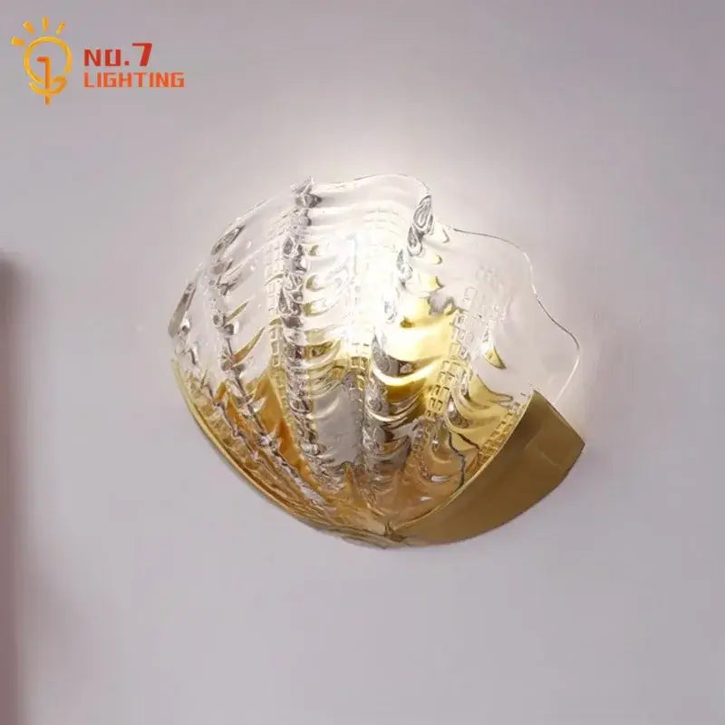 Luxury brass glass shell wall lamp with a translucent textured glass shade and gold-toned metal base for bedroom decorbites brass glass