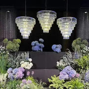 Luxury cascading crystal ice bar chandelier with three tiered faceted design hanging above floral decorbites crystal ice