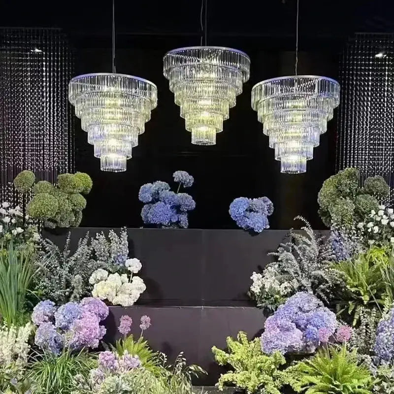 Luxury cascading crystal ice bar chandelier with three tiered faceted design hanging above floral decorbites crystal ice