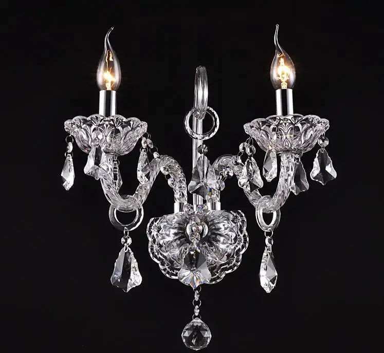 Luxury clear crystal wall lamp bedroom candle sconce with two lit bulbs and intricate cut glass arms by decorbites clear crystal