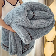 Luxury coral fleece winter blanket in light gray with textured woven pattern and dark brown trim for bedroom use