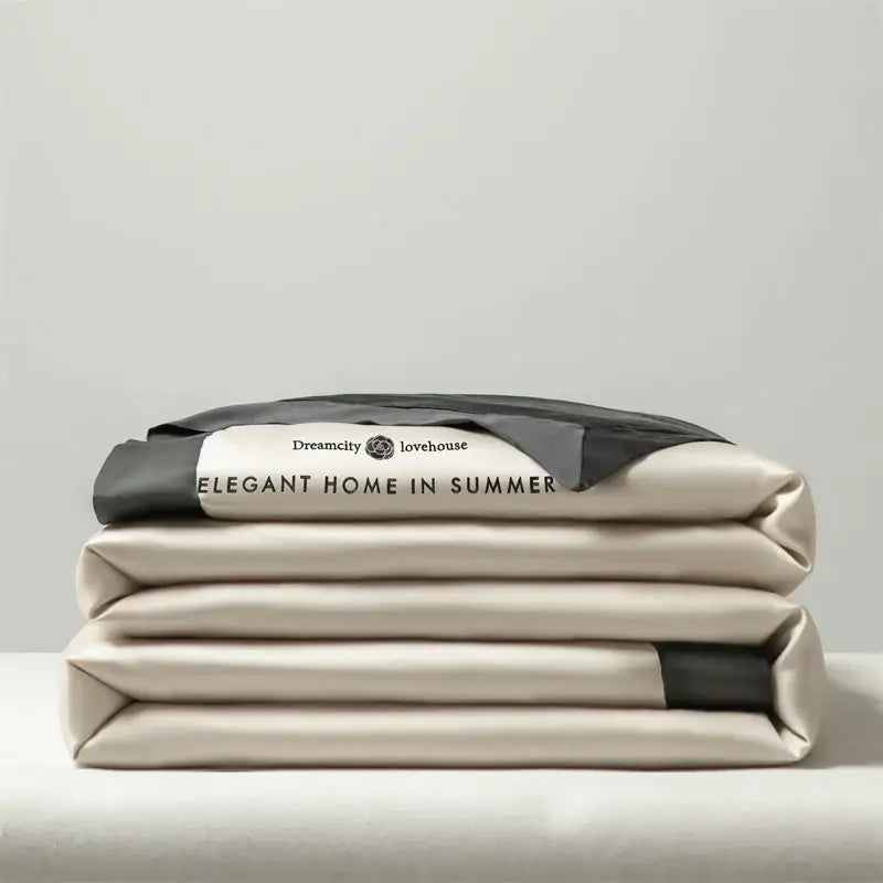 Luxury cream and black ice silk embroidered quilt set with beige satin sheets featuring elegant home in summer label