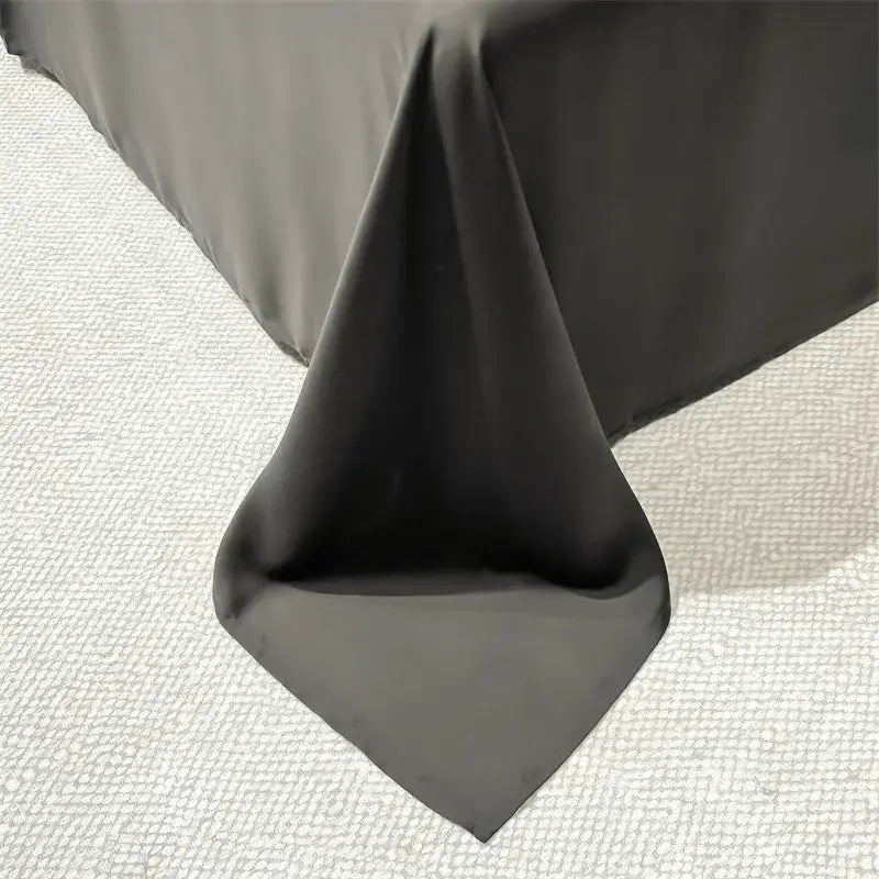 A dark gray ice silk embroidered tablecloth drapes elegantly complementing the luxury cream and black quilt set décorbites ice silk