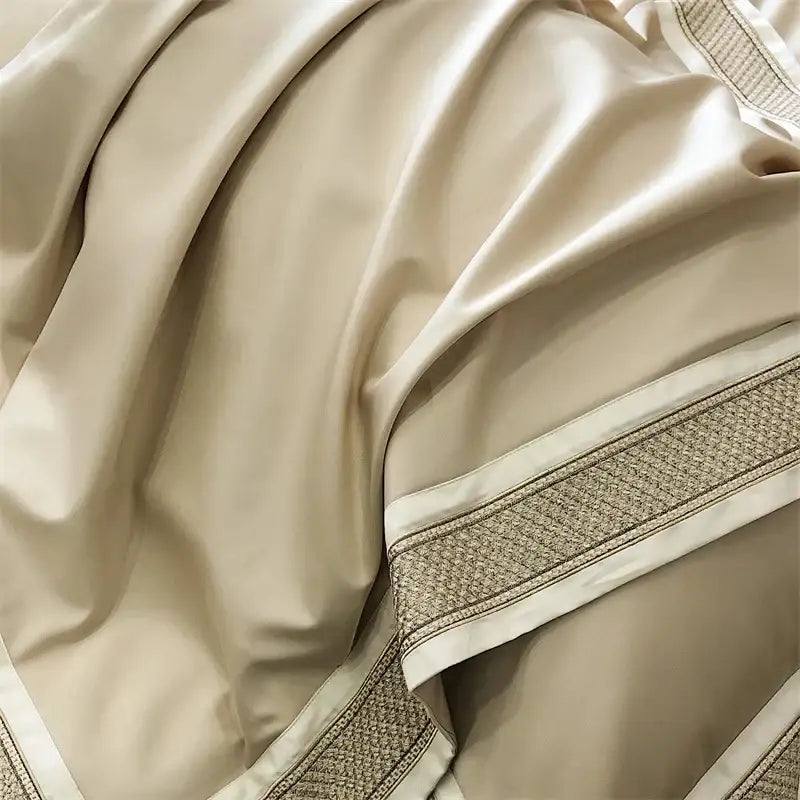 Cream-colored satin bedding set with subtle sheen and decorative woven border trim from decorbites 1000tc luxury embroidery