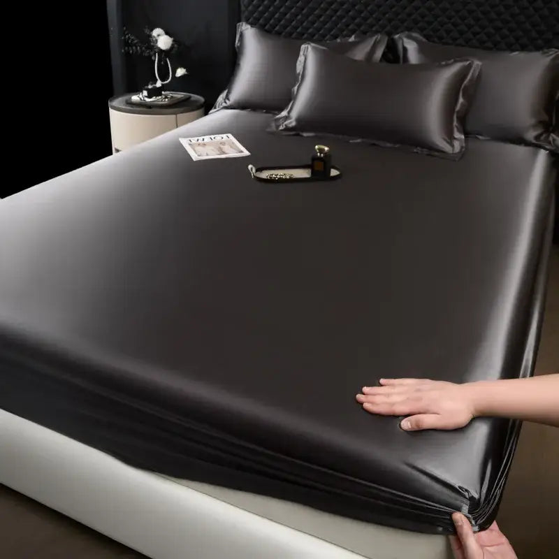 Luxury cream mulberry silk fitted sheet set featuring a black satin fitted sheet with a smooth glossy finish