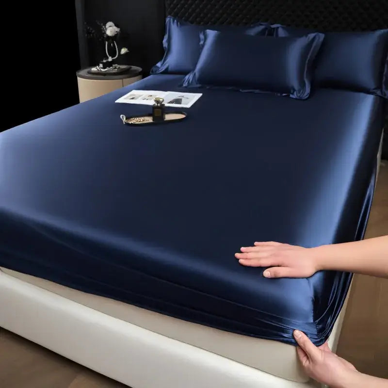 Luxury deep navy satin fitted sheet set with matching pillowcases featuring a smooth glossy finish for bedroom use
