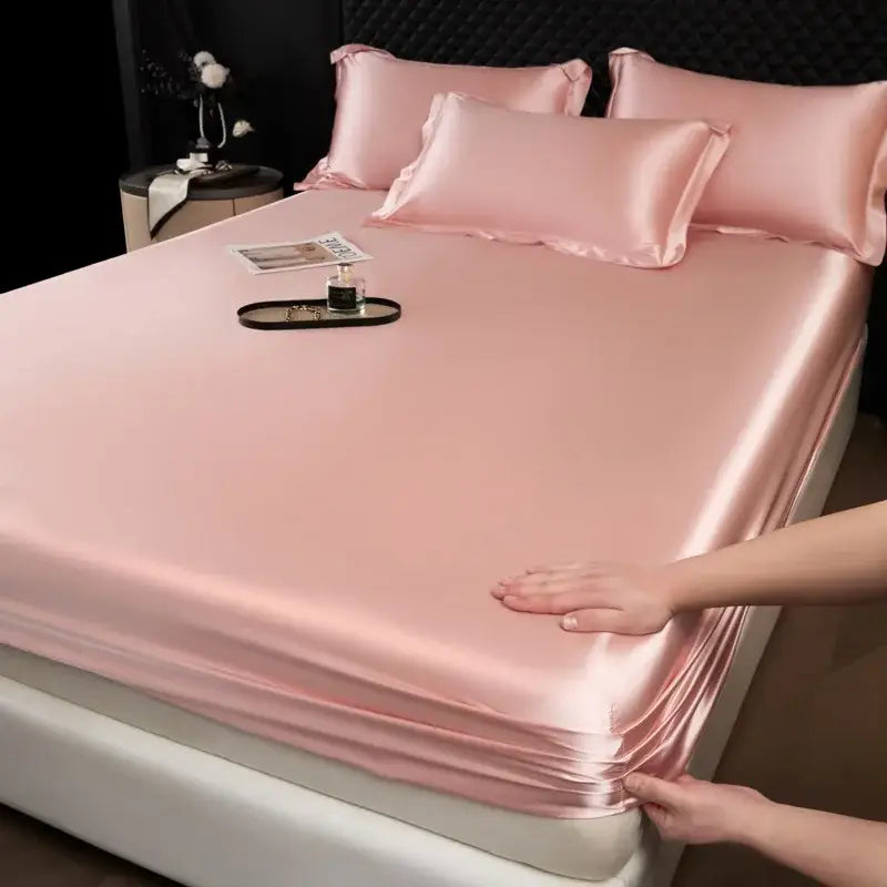 Pink satin fitted sheet set with matching pillowcases made from luxury cream mulberry silk for bedroom use