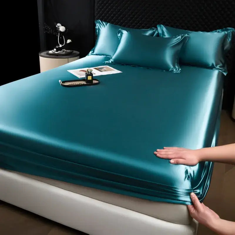 Luxury cream mulberry silk fitted sheet set in teal satin with a smooth glossy finish and elegant drape for bedroom use