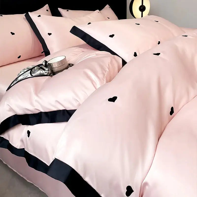 Luxury cream and pink ice silk bedding sets featuring pink satin duvet cover with black heart embroidery and navy trim by decorbites ice silk