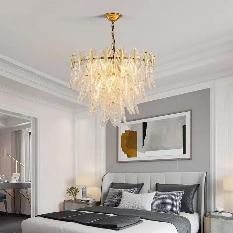 A luxury chandelier featuring a gold-toned metal frame with cascading translucent glass leaf decorbites glass leaf elements