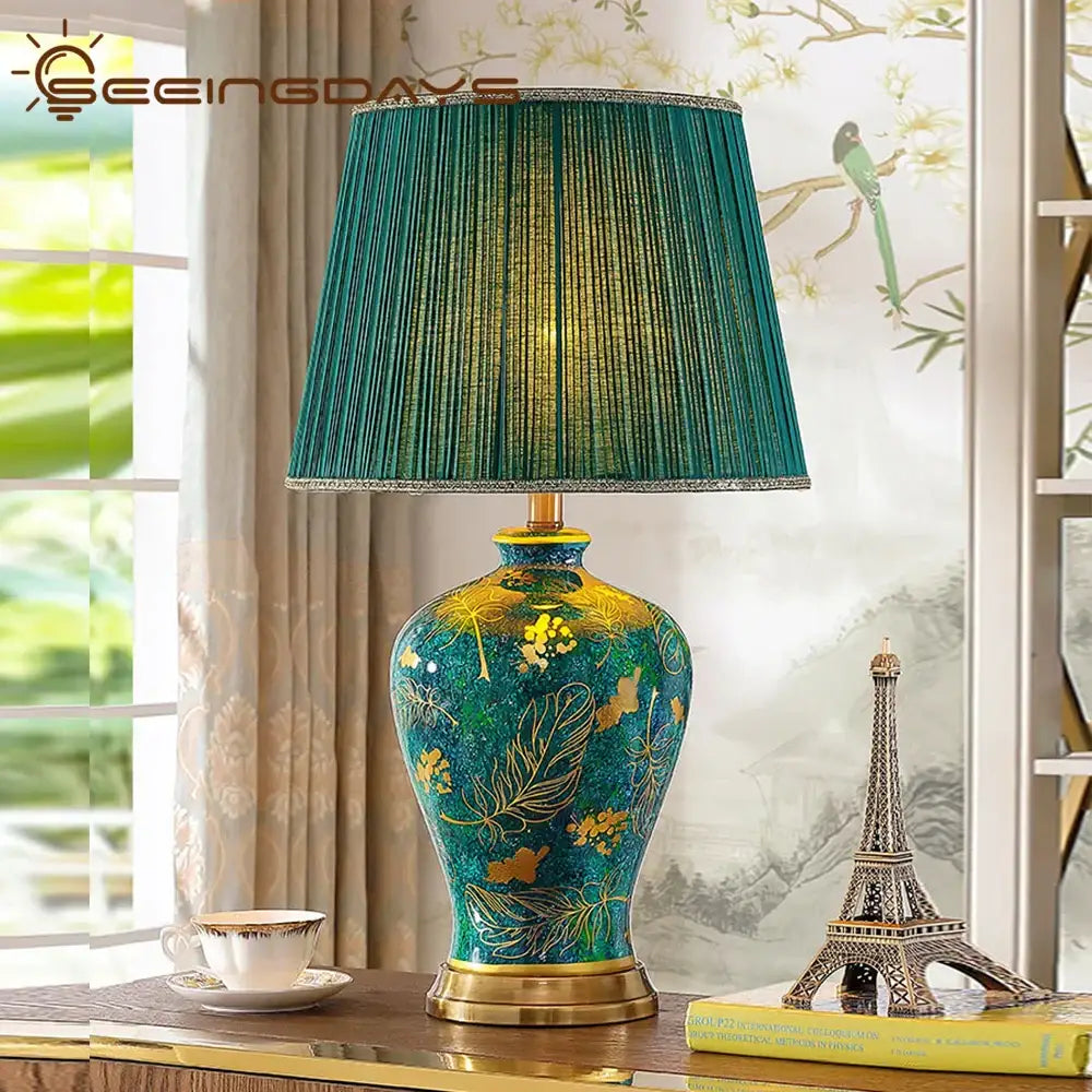 Luxury emerald queen green ceramic table lamp with a teal and gold floral base and pleated green fabric shade for bedroom lighting