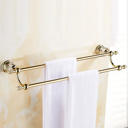 Luxury gold and crystal bath hardware double towel rack with crystal embellishments and two white towels hanging