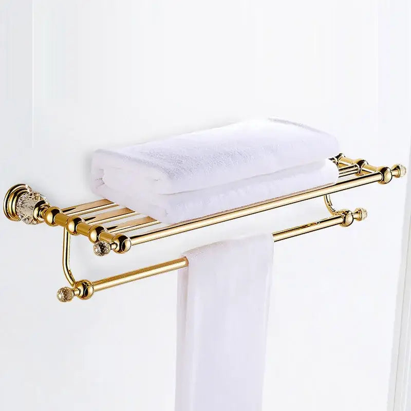Luxury gold and crystal bath hardware towel rack with dual-tier design holding white towels for bathroom use