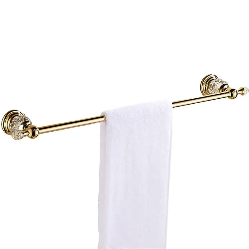 Luxury gold and crystal bath hardware towel rack with ornate ends holding a white towel for bathroom accessories