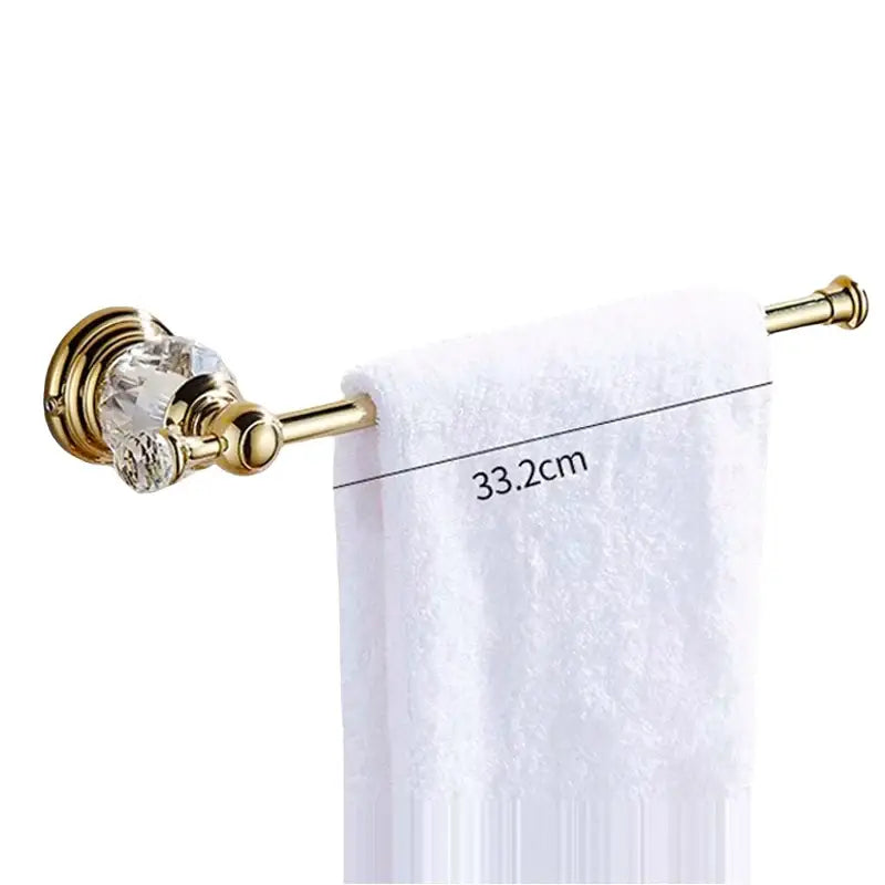 Luxury gold and crystal bath hardware towel rack with crystal accents holding a white textured towel