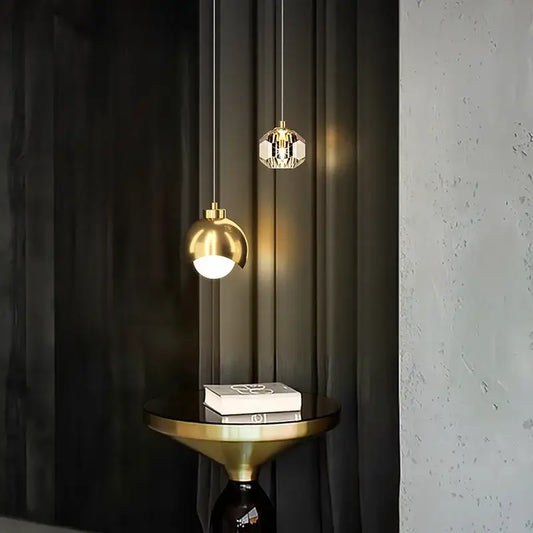 Two elegant pendant lights feature a polished gold decorbites glass ball and a faceted crystal glass ball pendant light