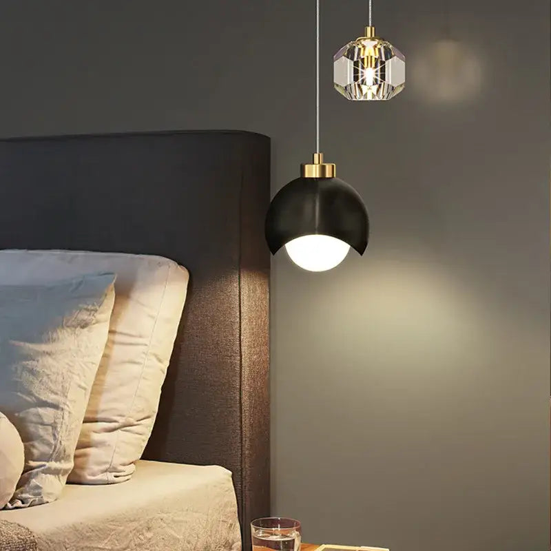 Two luxury gold and crystal glass ball pendant lights feature black matte and faceted glass shades for living room decor