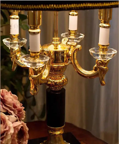 Luxury gold and black crystal table lamp with golden candelabra, white candles, and black marble base for black crystal bedroom decor
