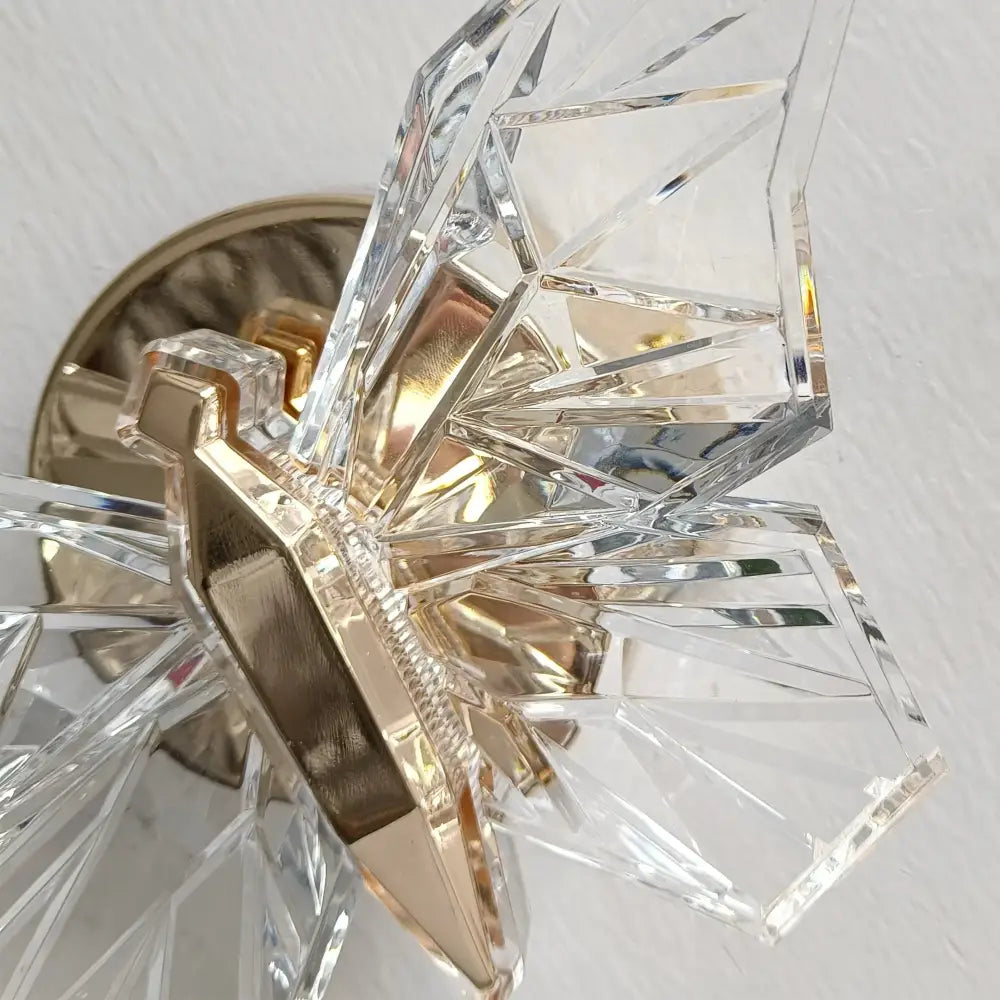 Luxury gold butterfly wall lamp featuring clear faceted crystal and gold-toned metal accents for bedroom lighting