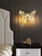 A golden sculpted boot-shaped decorative object with a reflective metallic finish complements the luxury gold butterfly wall lamp