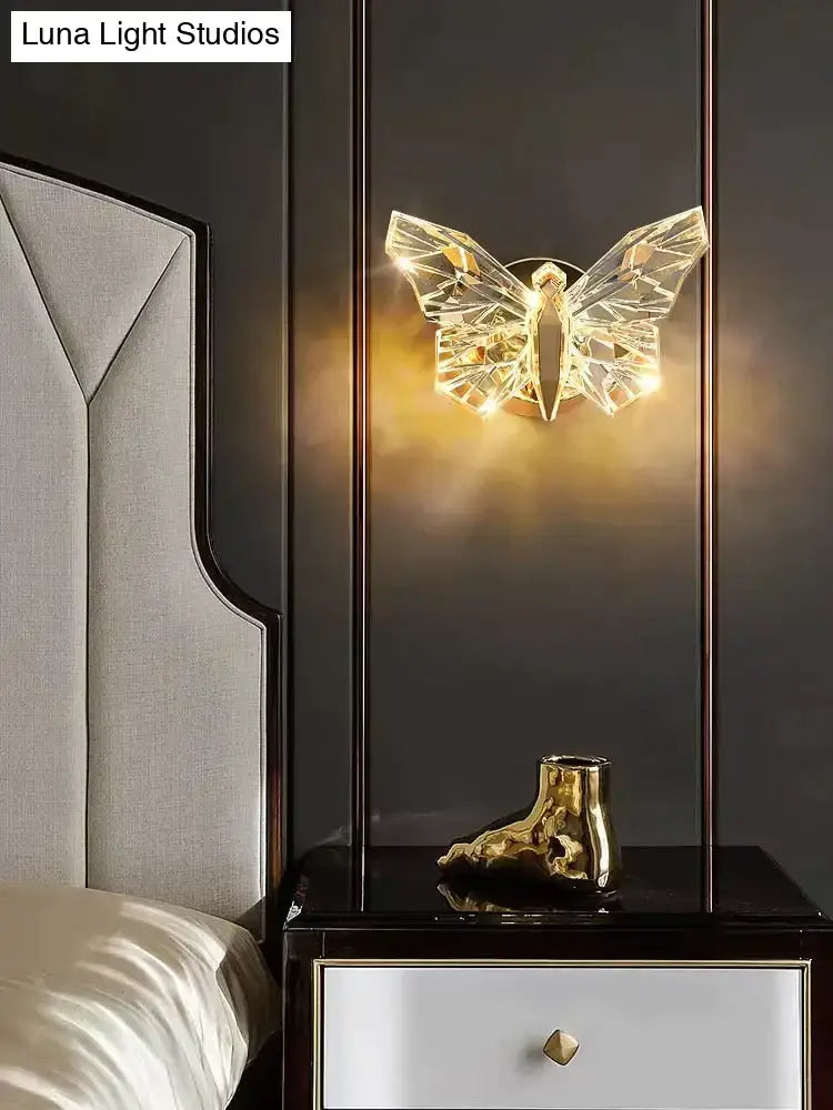Luxury gold butterfly wall lamp featuring faceted crystal wings for elegant bedroom lighting