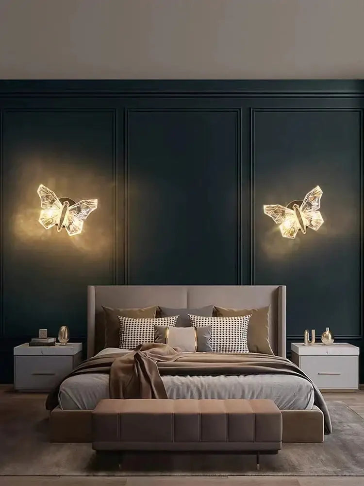 Two illuminated luxury gold butterfly wall lamps with crystalline design emitting warm glow for bedroom lighting