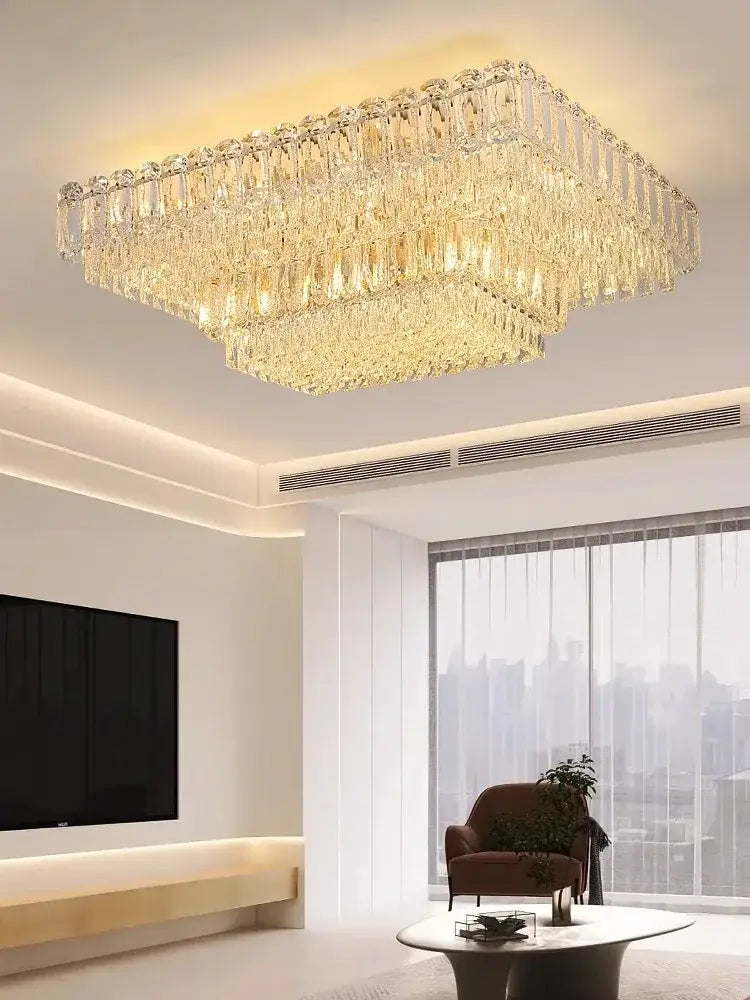 Luxury gold and clear crystal round ceiling lamp with rectangular faceted glass tiers emitting warm golden glow