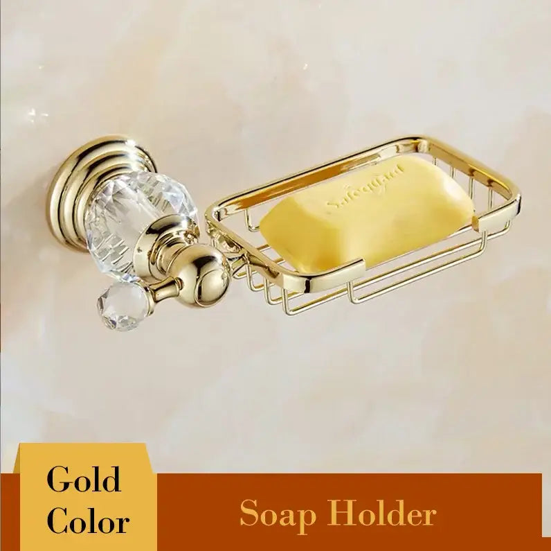 Gold-colored metal soap holder with crystal knobs and wire mesh tray holding yellow soap from decorbites brass bathroom set
