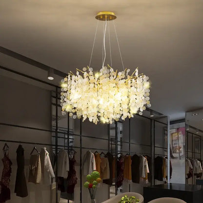 Luxury gold crystal led chandelier with delicate glass flower elements suspended from a brass ceiling mount decorbites crystal led
