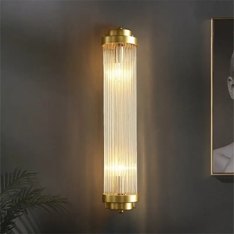 Luxury gold crystal led wall sconce with vertical glass prisms designed as an elegant bedroom led wall light