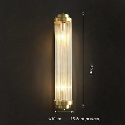 Luxury gold crystal led wall sconce with brass finish and vertical glass prisms emitting warm light for bedroom use