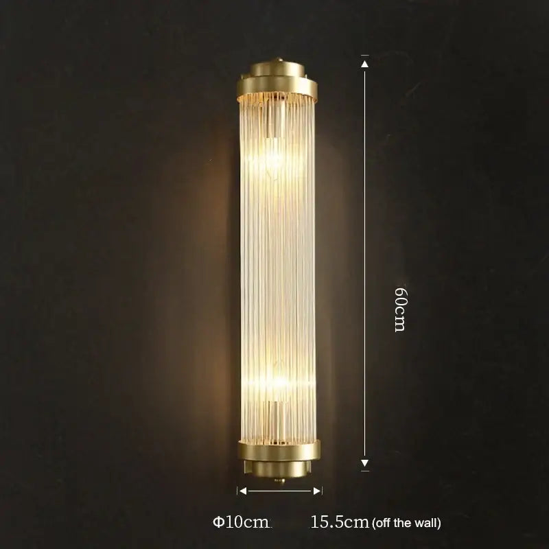 Luxury gold crystal led wall sconce with brass finish and vertical glass prisms emitting warm light for bedroom use