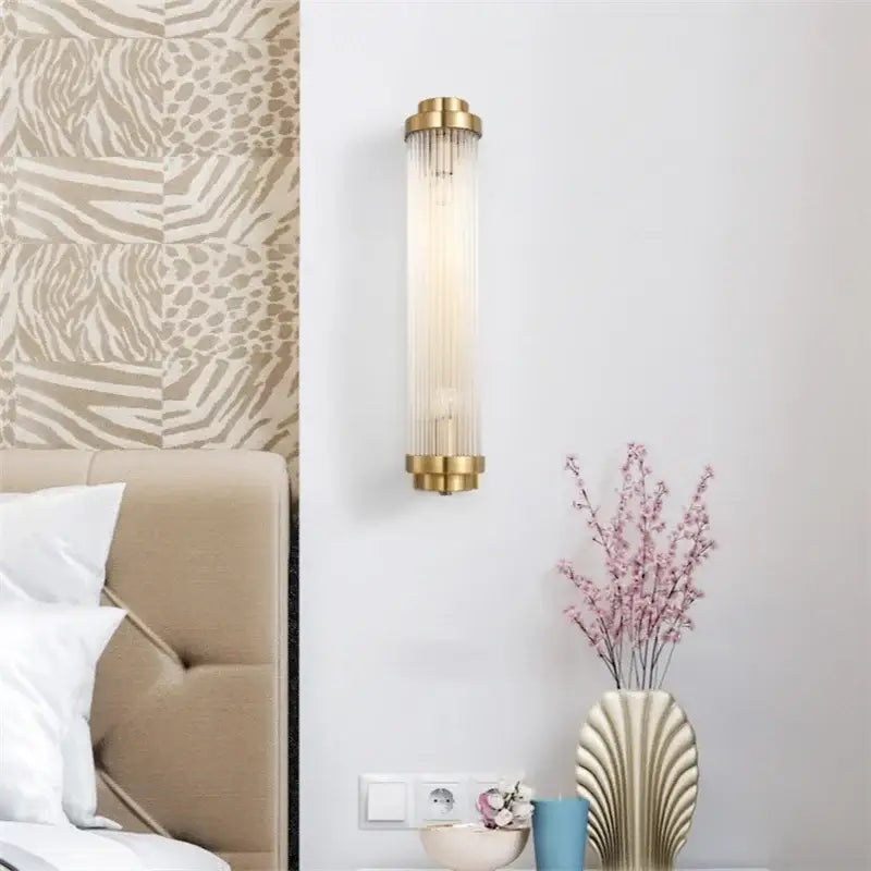 Luxury gold crystal led wall sconce with brass finish and vertical glass prisms for elegant bedroom lighting