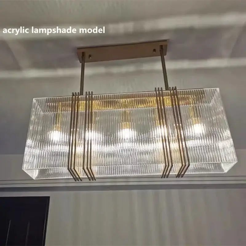 Luxury gold crystal rectangular pendant lights featuring acrylic lampshade with vertical ridges and brass frame for dining room decorbites gold lustre