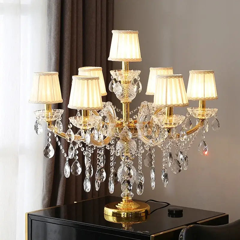 Luxury gold crystal table light with cream fabric shades and dangling teardrop crystals for elegant bedroom décor