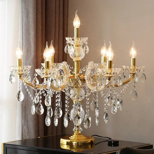 Luxury gold crystal table light featuring candle-like bulbs and dangling teardrop crystals for elegant bedroom use