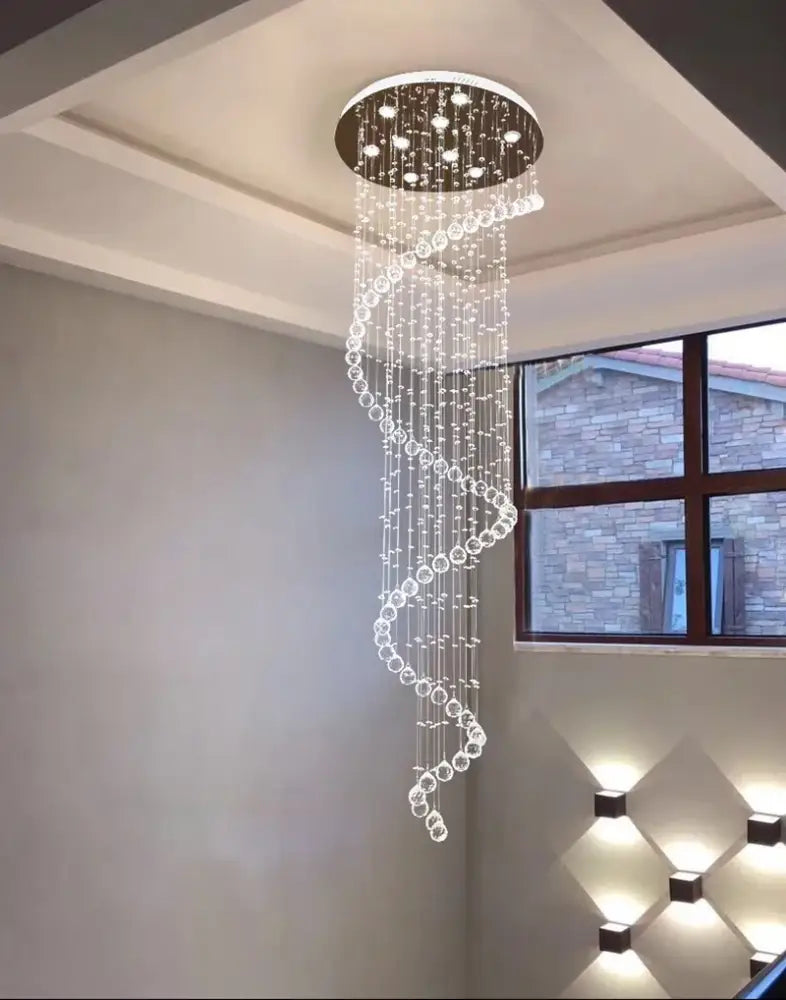 A modern luxury gold decorbites k9 crystal spiral chandelier with clear beads and circular metallic top for living space