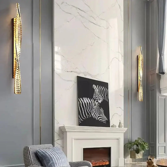 Luxury gold dimmable crystal wall sconce with textured elongated design flanking marble fireplace for decorbites lighting
