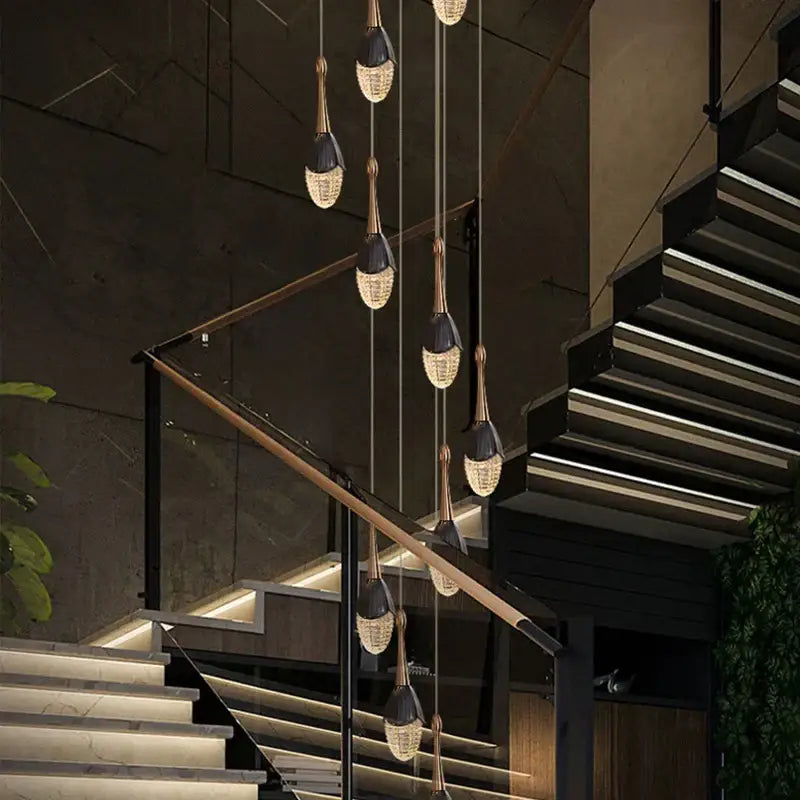 Luxury gold led staircase chandelier featuring modern black and gold pendant lights with crystal teardrop shades decorbites gold led