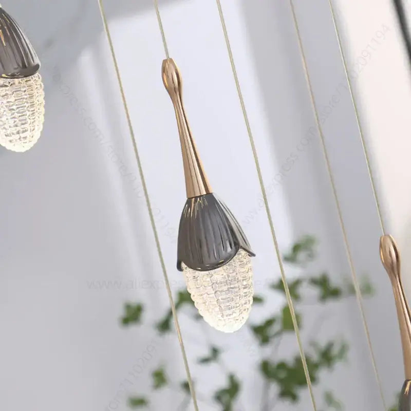 Luxury gold led staircase chandelier with a gold-toned stem and dark gray faceted glass shade by decorbites gold led