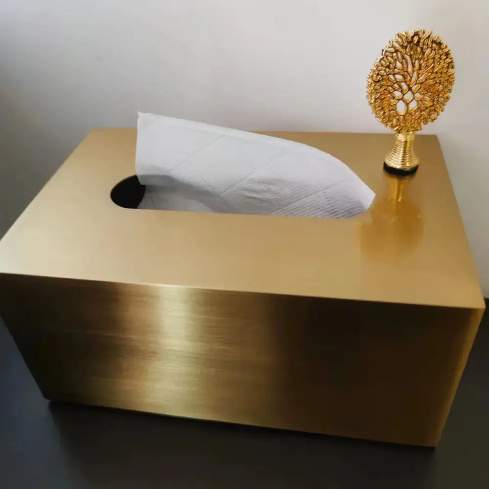 Luxury gold metal tissue box with deer figurine featuring a sleek brushed surface and open top showing white quilted tissues