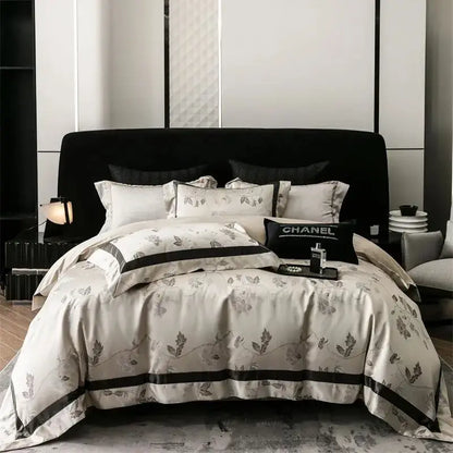 Cream-colored satin bedding set with gray botanical embroidery and black piping in decorbites brocade satin jacquard design