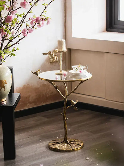 Luxury golden brass bird tree side table with reflective glass top and intricate branch-like base for living room decorbites brass bird decor