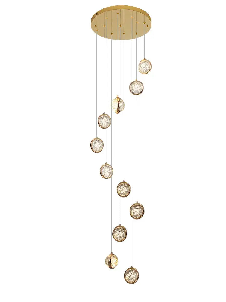 Gold-toned rotating stair chandelier with decorbites crystal ball led orbs encased in metallic rims for luxury decor