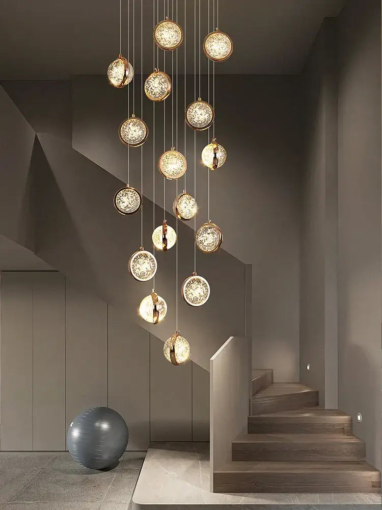 A modern luxury golden decorbites crystal ball led rotating stair chandelier with spherical glass orbs in metal frames
